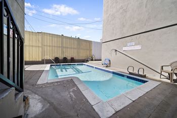 A small pool with a diving board and a sign that says "SWIMMING POOL".